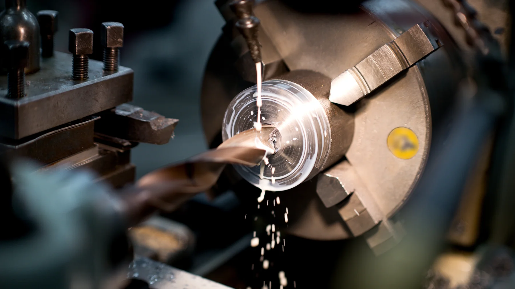Metal turning on a lathe with coolant flowing across the cutting tool